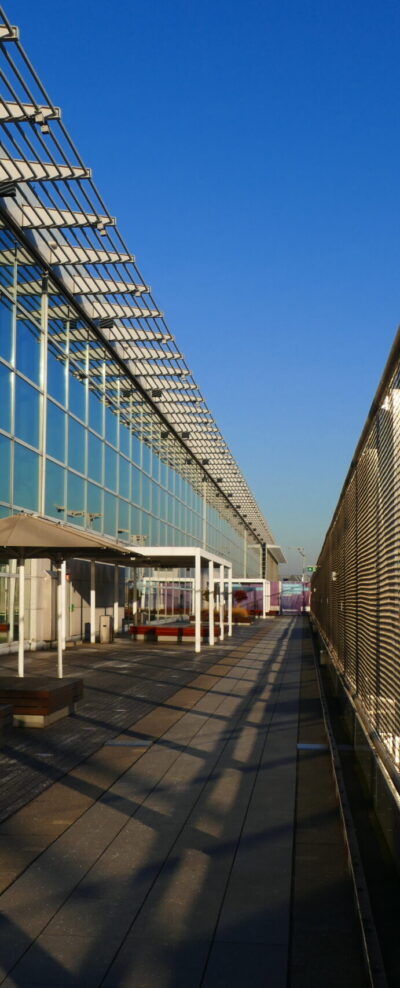 Terrace with modern architecture, security wire nets under blue sky and shadow structures on the floor.